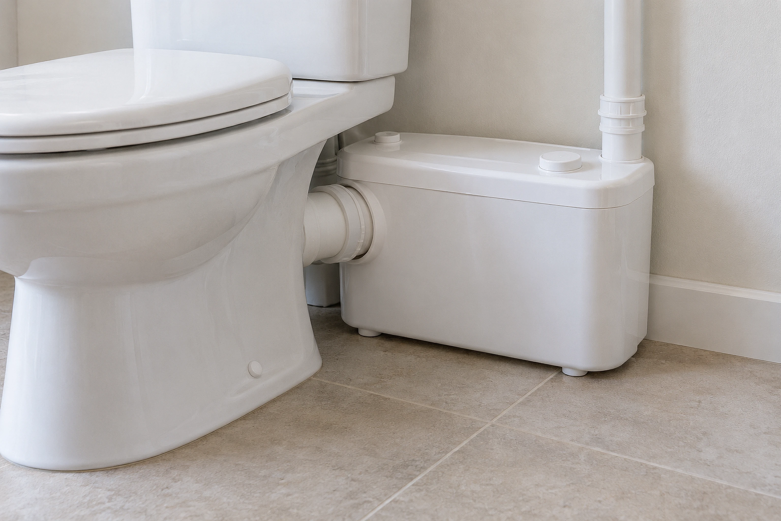 Illustrative compact WC macerator behind a toilet